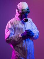 Coronavirus covid-19 pandemic. Doctor scientist wearing protective biological suit and mask due to global healthcare epidemic warning and danger background in blue and pink neon lights background. photo