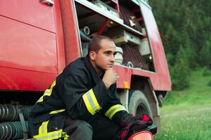 Deprimido y cansado bombero cerca fuego camión. foto