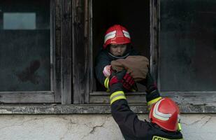 bombero héroe que lleva bebé niña fuera desde ardiente edificio zona desde fuego incidente. rescate personas desde peligroso sitio foto