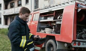 depressed and tired firefighter near fire truck. photo