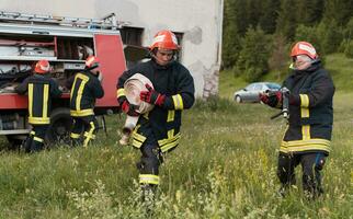 Group of fire fighters standing confident after a well done rescue operation. Firemen ready for emergency service. photo