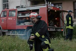 Deprimido y cansado bombero cerca fuego camión. foto