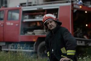 Deprimido y cansado bombero cerca fuego camión. foto