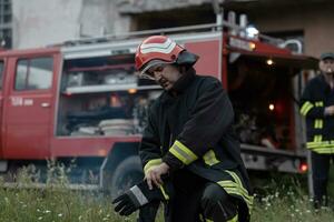 depressed and tired firefighter near fire truck. photo