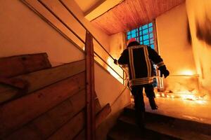 Brave Fireman going upstairs to save and rescue people in a Burning Building. Open fire and flame. photo