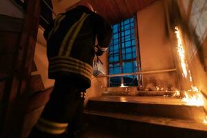 Brave Fireman going upstairs to save and rescue people in a Burning Building. Open fire and flame. photo