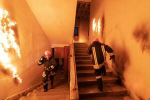 valiente bombero yendo piso de arriba a salvar y rescate personas en un ardiente edificio. abierto fuego y fuego. foto