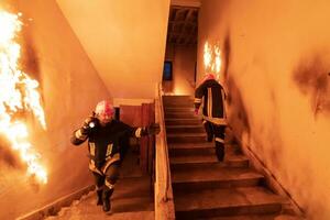 valiente bombero yendo piso de arriba a salvar y rescate personas en un ardiente edificio. abierto fuego y fuego. foto