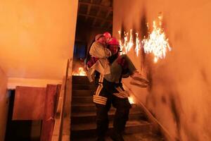 valiente bombero desciende escalera de un ardiente edificio y sostiene salvado niña en su brazos. abierto fuego y uno bombero en el antecedentes. foto