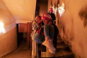 Brave Fireman Descends Stairs of a Burning Building and Holds Saved Girl in His Arms. Open fire and one Firefighter in the Background. photo