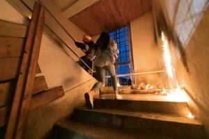 Brave Fireman going upstairs to save and rescue people in a Burning Building. Open fire and flame. photo