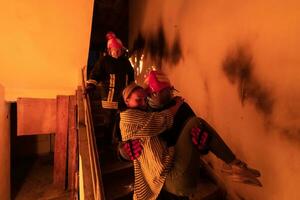 Brave Fireman Descends Stairs of a Burning Building and Holds Saved Girl in His Arms. Open fire and one Firefighter in the Background. photo