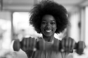 woman working out in a crossfit gym with dumbbells photo