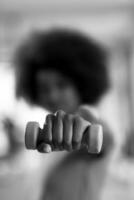 woman working out in a crossfit gym with dumbbells photo