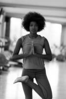 mujer afroamericana ejercicio yoga en el gimnasio foto