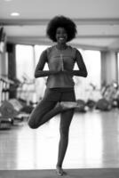 mujer afroamericana ejercicio yoga en el gimnasio foto