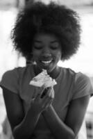woman with afro hairstyle eating tasty pizza slice photo