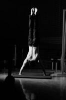 young man performing handstand in fitness studio photo