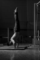 young man performing handstand in fitness studio photo