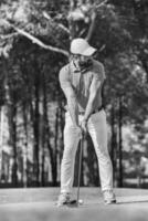 golf player hitting shot with club photo