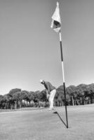 golf player hitting shot with club on course photo