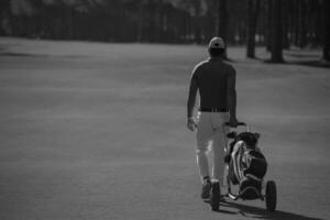 jugador de golf caminando con bolsa de ruedas foto