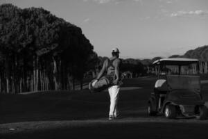 golfista caminando y llevando una bolsa de golf foto