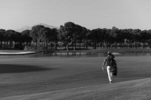 golfer  walking and carrying bag photo