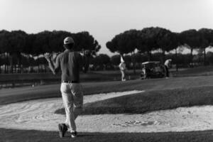 golfista desde atrás en el campo mirando al hoyo en la distancia foto