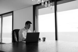 frustrated young business man working on laptop computer at home photo