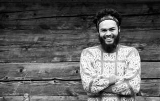 portrait of young hipster in front of wooden house photo