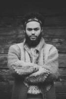 portrait of young hipster in front of wooden house photo