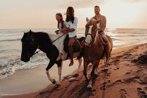 The family spends time with their children while riding horses together on a sandy beach. Selective focus photo