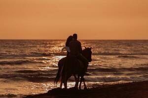 The family spends time with their children while riding horses together on a sandy beach. Selective focus photo