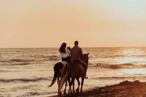 The family spends time with their children while riding horses together on a sandy beach. Selective focus photo