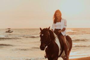 Woman in summer clothes enjoys riding a horse on a beautiful sandy beach at sunset. Selective focus photo