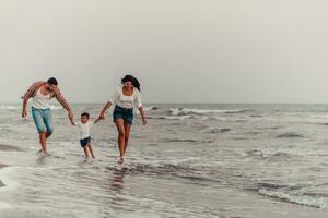 The family enjoys their vacation as they walk the sandy beach with their son. Selective focus photo