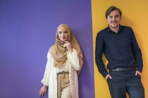 Portrait of a young Muslim couple woman in fashionable dress with hijab isolated on a colorful background representing modern Islam fashion and Ramadan Kareem concept photo