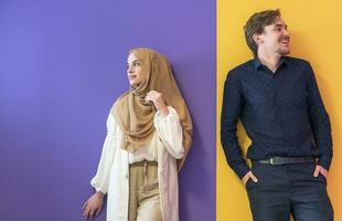 Portrait of a young Muslim couple woman in fashionable dress with hijab isolated on a colorful background representing modern Islam fashion and Ramadan Kareem concept photo