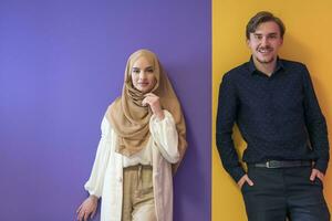 Portrait of a young Muslim couple woman in fashionable dress with hijab isolated on a colorful background representing modern Islam fashion and Ramadan Kareem concept photo