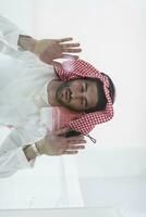 hombre musulmán haciendo sujud o sajdah en el suelo de cristal foto