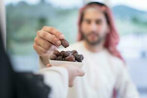 modern multiethnic muslim family sharing a bowl of dates while enjoying iftar dinner together during a ramadan feast at home photo