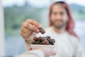 modern multiethnic muslim family sharing a bowl of dates while enjoying iftar dinner together during a ramadan feast at home photo