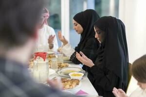 familia musulmana haciendo iftar dua para romper el ayuno durante el ramadán. foto