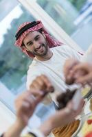 moderno multiétnico musulmán familia compartiendo un cuenco de fechas mientras disfrutando iftar cena juntos durante un Ramadán banquete a hogar foto