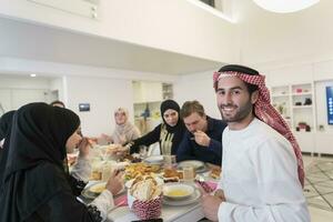 joven árabe hombre teniendo iftar cena con musulmán familia comiendo tradicional comida durante Ramadán banquete mes a hogar. el islámico halal comiendo y Bebiendo islámico familia foto