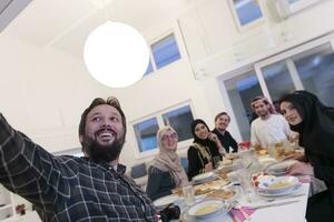 eid Mubarak musulmán familia teniendo iftar cena tomando imágenes con móvil teléfono mientras comiendo tradicional comida durante Ramadán banquete mes a hogar. el islámico halal comiendo y Bebiendo islámico famil foto