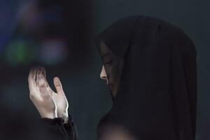 Portrait of young Muslim woman making dua photo