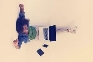 african american woman sitting on floor with laptop top view photo