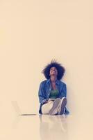 african american woman sitting on floor with laptop photo